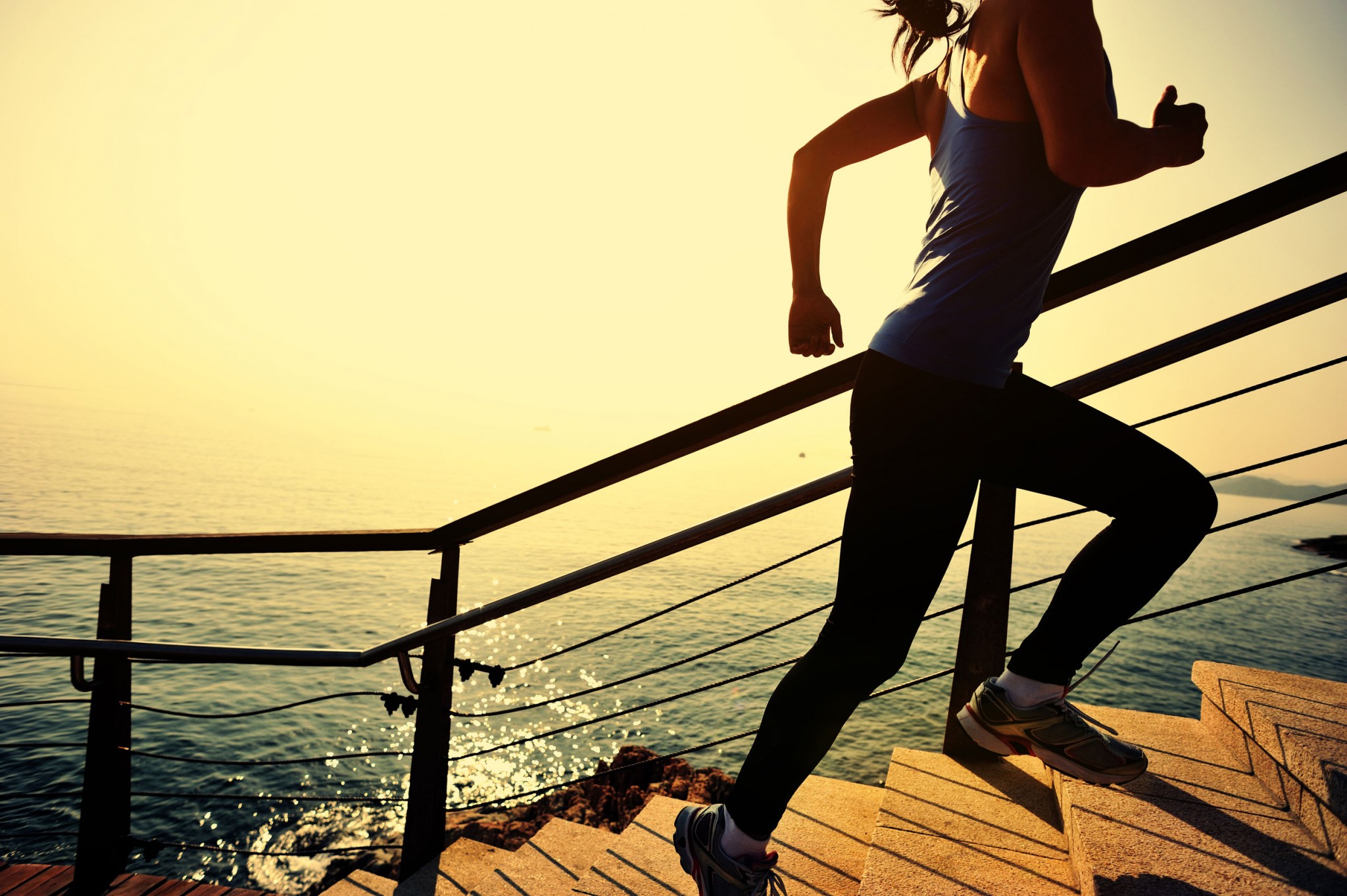 sports-woman-running-up-on-stone-stairs-sunrise