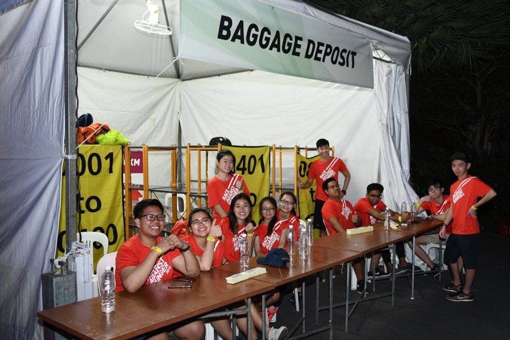 Friendly volunteers at the baggage deposit booth. Credit to Pink Apple Events.